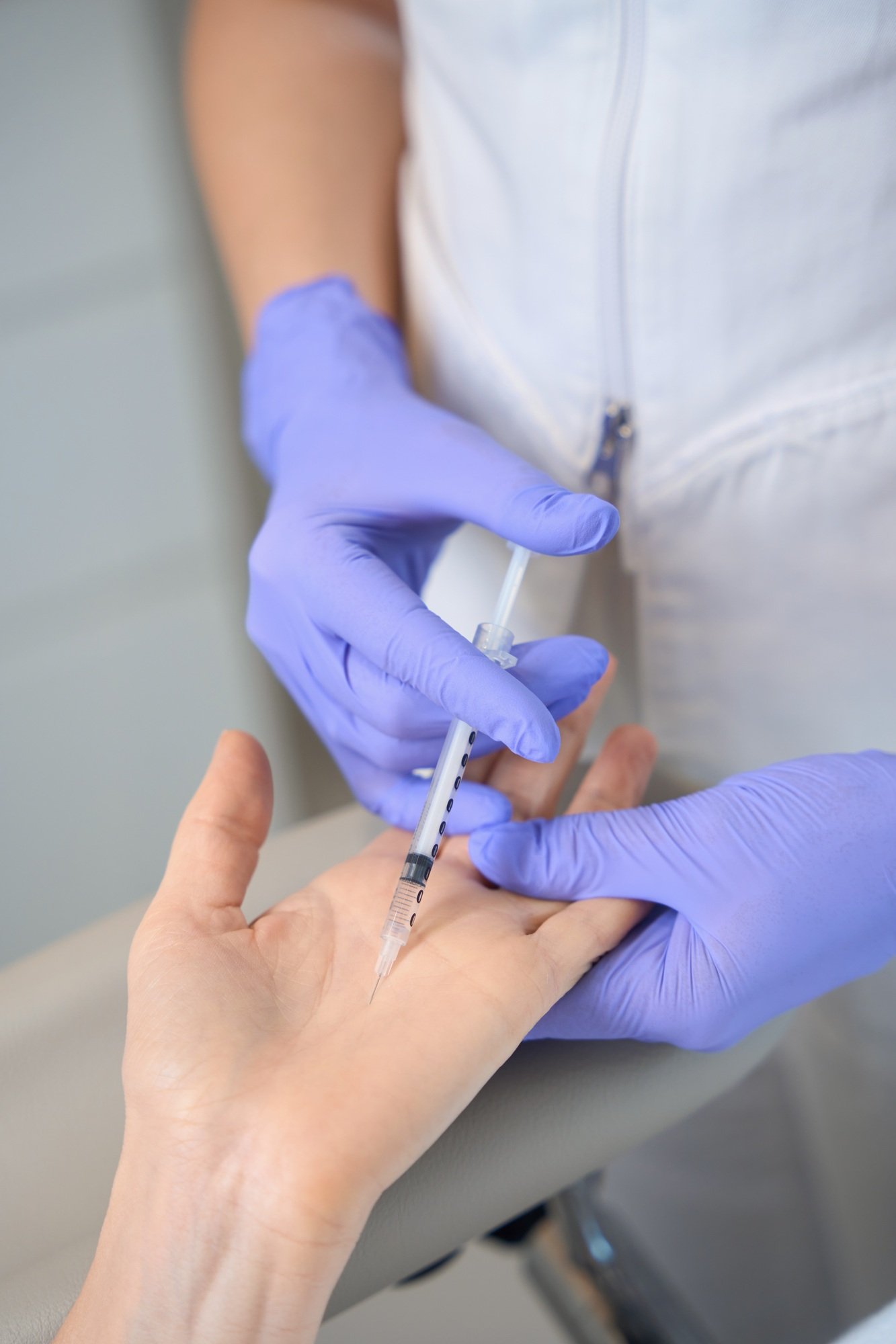 Closeup of doctor hands in gloves making palm injection